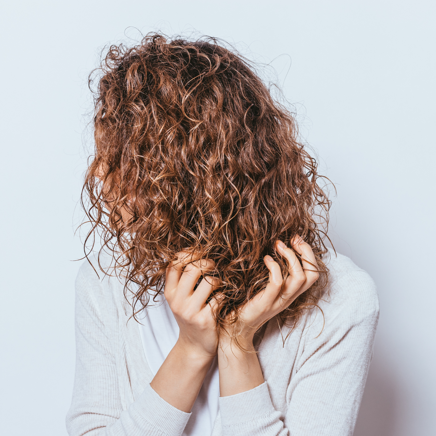 image of woman with curly hair scrunching her hair